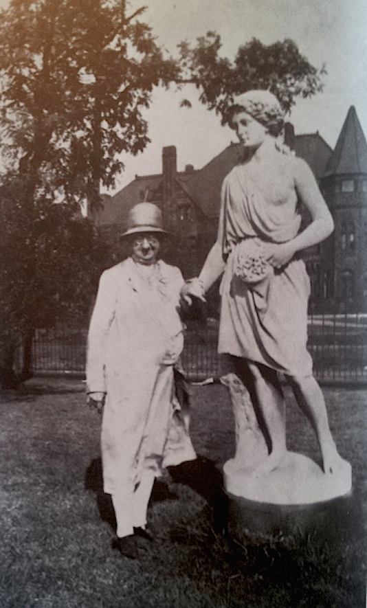 Ella Grant Wilson was a florist and historian for the avenue. She poses here with a sculpture in front of the Everett mansion.